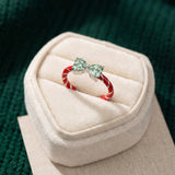 Candy Cane Ribbon Ring | Green Moissanite in silver, laid flat on a tabletop