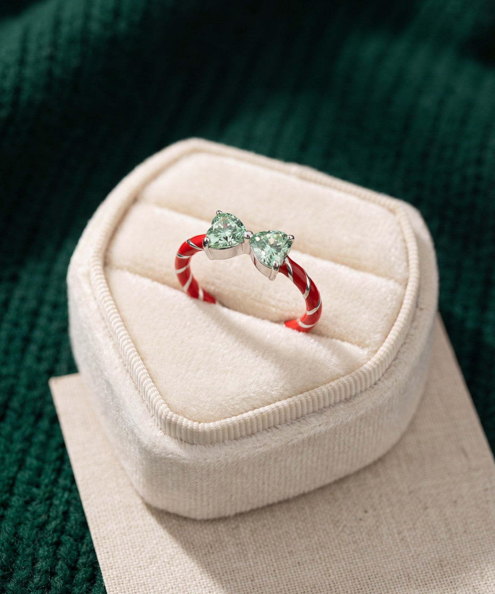 Candy Cane Ribbon Ring | Green Moissanite in silver, laid flat on a tabletop