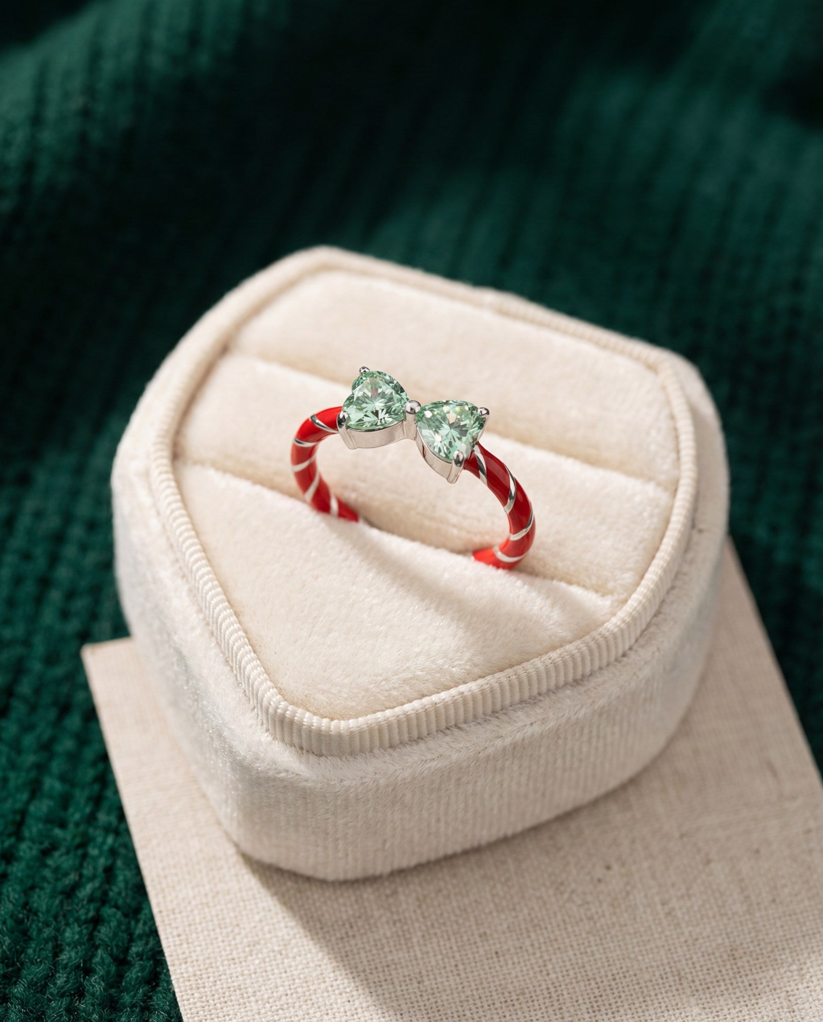 Candy Cane Ribbon Ring | Green Moissanite in silver, laid flat on a tabletop