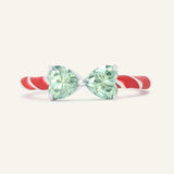 Close-up of the Candy Cane Ribbon Ring | Green Moissanite in silver, resting on a warm linen background