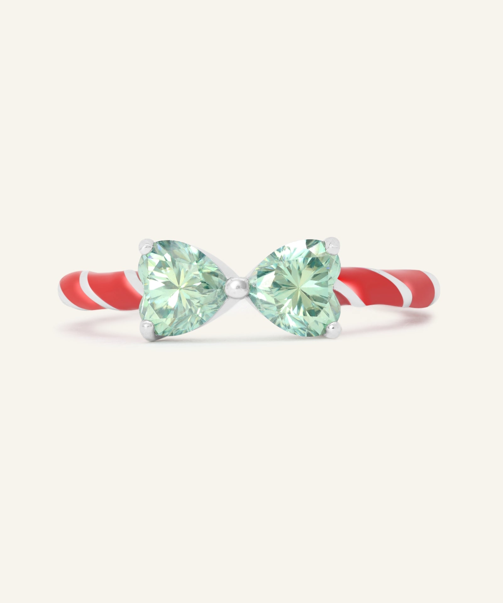 Close-up of the Candy Cane Ribbon Ring | Green Moissanite in silver, resting on a warm linen background