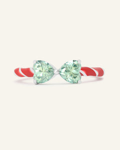 Close-up of the Candy Cane Ribbon Ring | Green Moissanite in silver, resting on a warm linen background