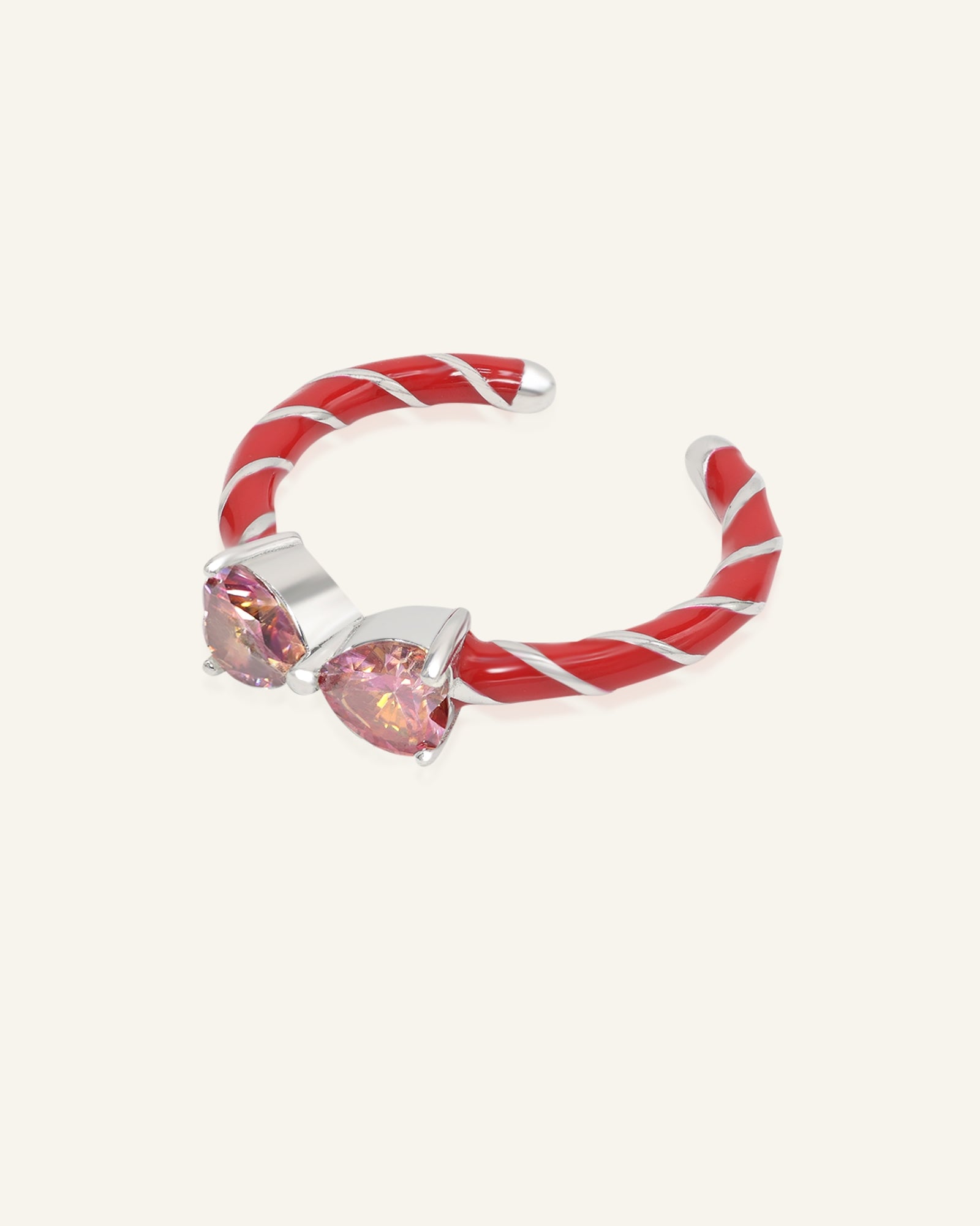 Candy Cane Ribbon Ring | Red Moissanite in silver, resting on a warm linen background