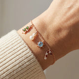 Christmas Charm Bracelet in rose gold, worn on a model