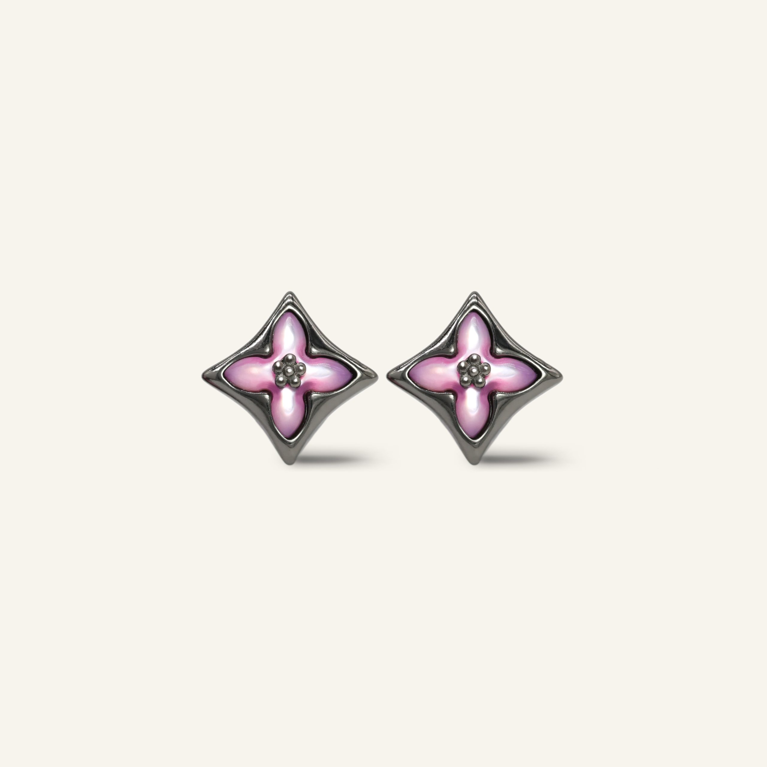 Close-up of a pair of black gold clover monogram studs