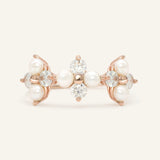 Trinity Clover Ring in rose gold, resting on a warm linen background