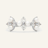 Trinity Clover Ring in silver, resting on a warm linen background