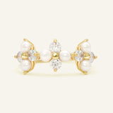 Close-up of the Trinity Clover Ring in yellow gold, resting on a warm linen background