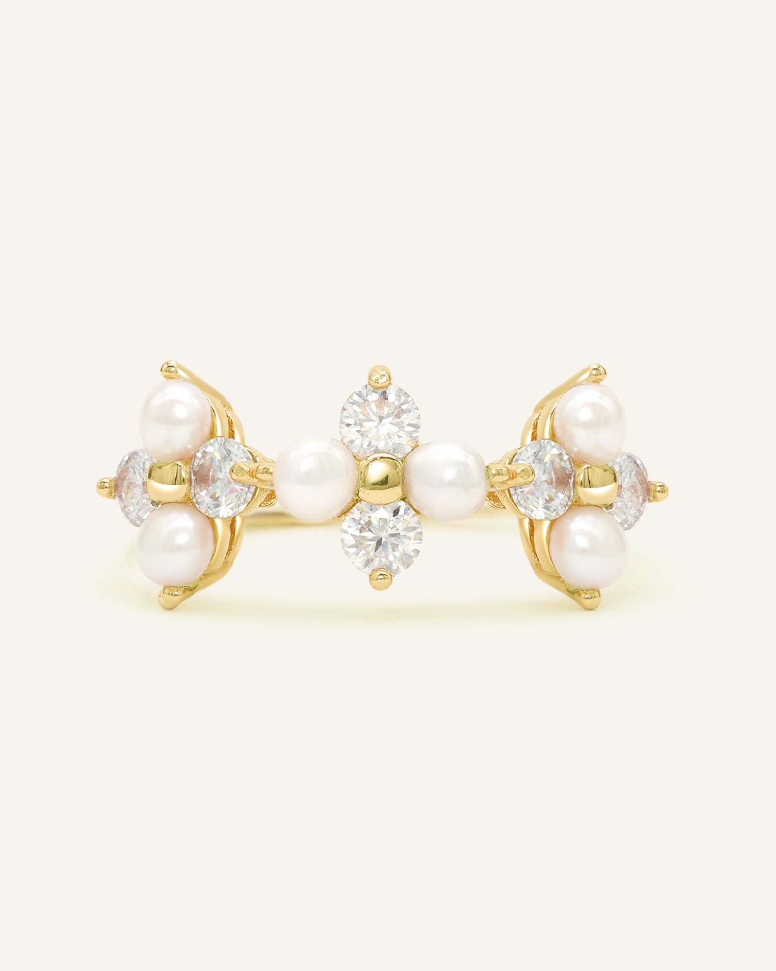Close-up of the Trinity Clover Ring in yellow gold, resting on a warm linen background
