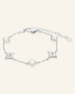Clover Monogram Bracelet | Elate in silver, resting on a warm linen background