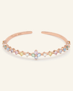 Close-up of the Clover Sparkle Cuff | Pastel Moissanite, Elate in rose gold, resting on a warm linen background