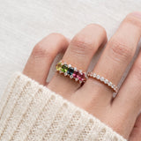 Model wearing a rose gold Color Burst Oval Ring with five natural gemstones stacked next to a delicate pavé band.