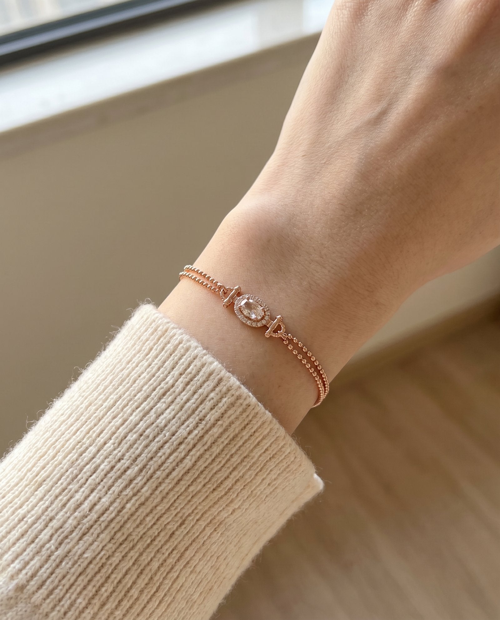 A close-up view of the rose gold Constance Petite Morganite Bracelet worn solo on a petite wrist, highlighting its elegant fit and the soft glow of the peach gemstone.