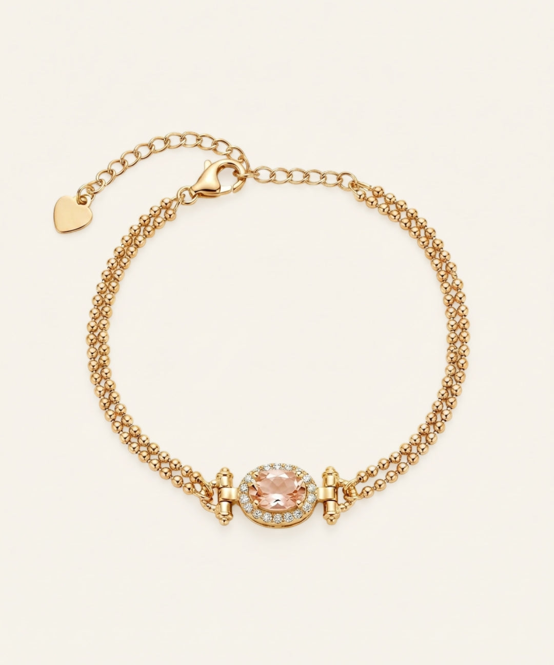 A top-down studio shot of the Constance Petite Morganite Bracelet in yellow gold, featuring a double-strand beaded chain and a peach morganite centerpiece with an oval halo.