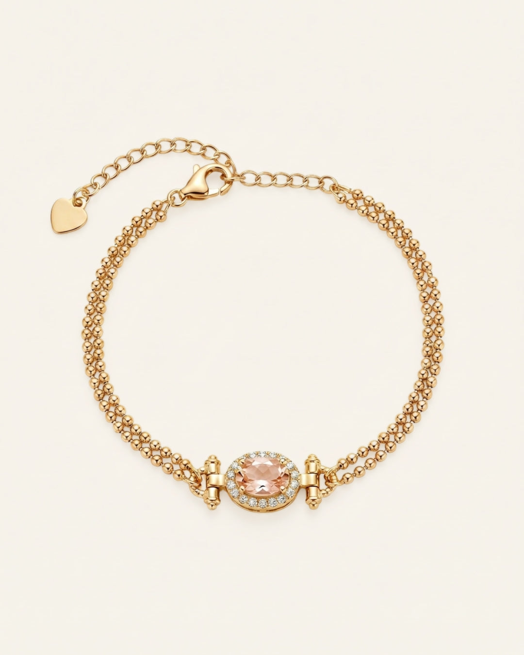A top-down studio shot of the Constance Petite Morganite Bracelet in yellow gold, featuring a double-strand beaded chain and a peach morganite centerpiece with an oval halo.