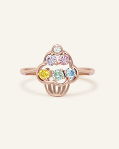 Close-up of the Unicorn Buttercream Cupcake Ring in rose gold, resting on a warm linen background