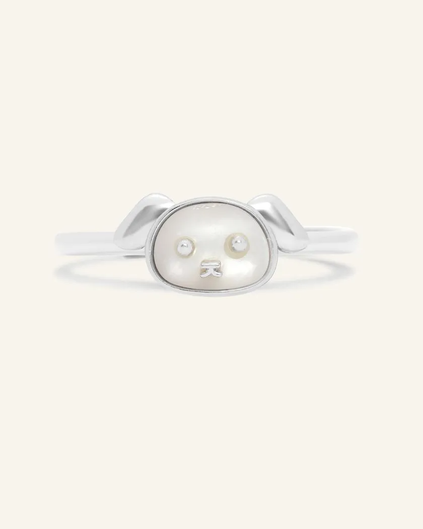 A silver ring featuring a mother of pearl centerpiece shaped like a dog's head.