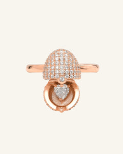 Close-up of the Dragon Egg Ring | White Moissanite, Interactive in rose gold, resting on a warm linen background