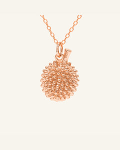Durian Citrine Necklace in rose gold, resting on a warm linen background