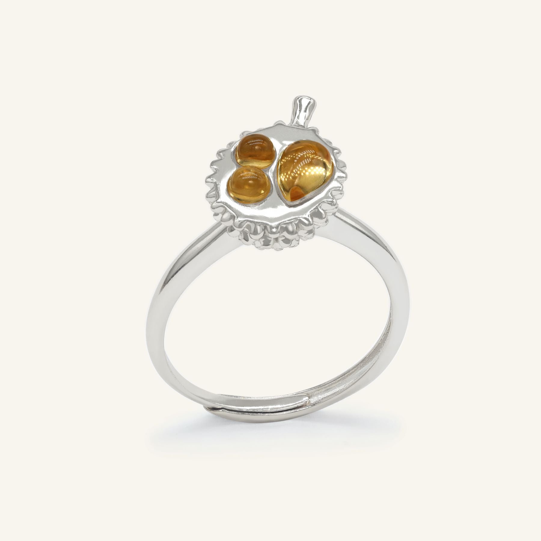 Durian Citrine Ring in silver, resting on a warm linen background