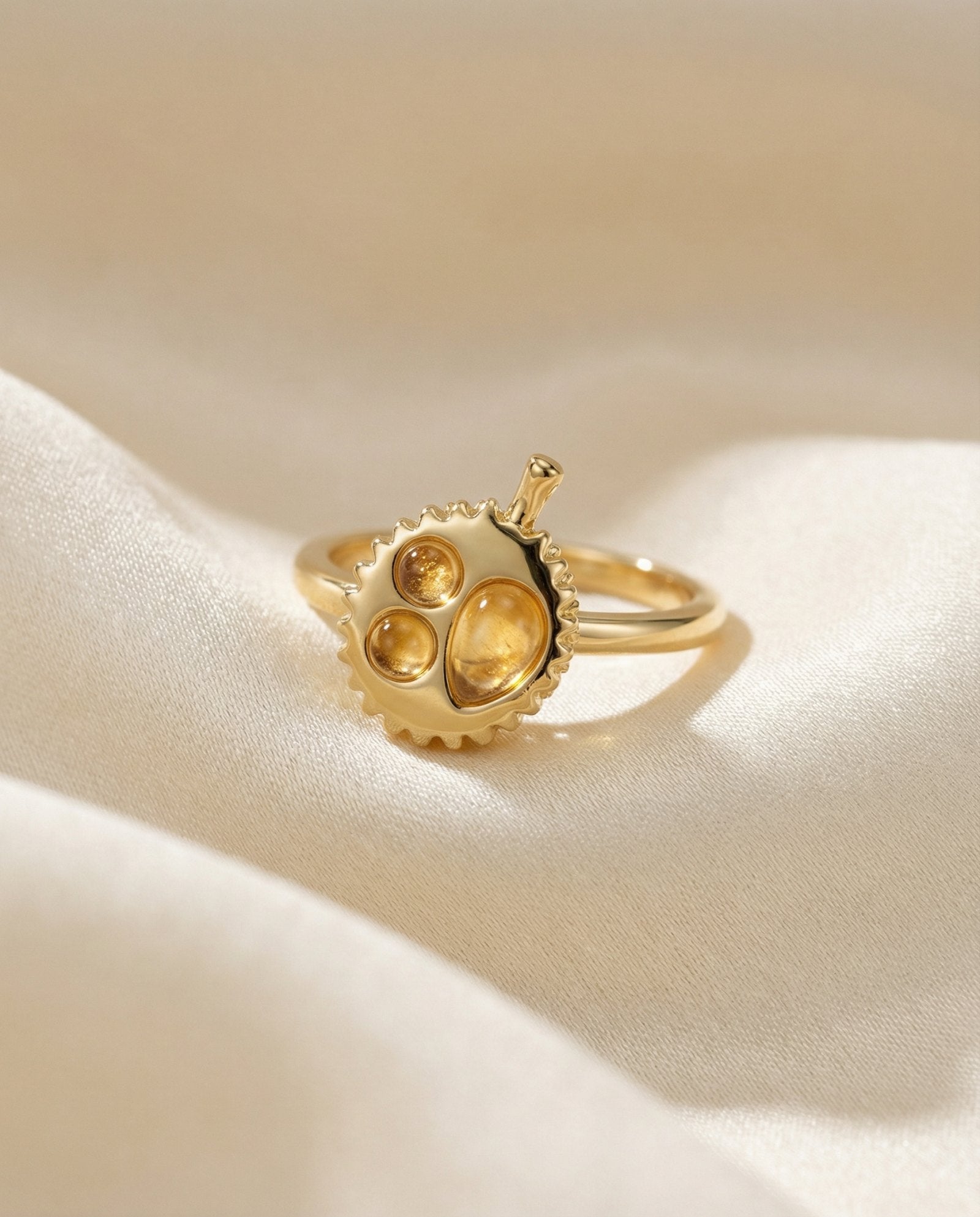 Durian Citrine Ring in yellow gold, laid flat on a tabletop