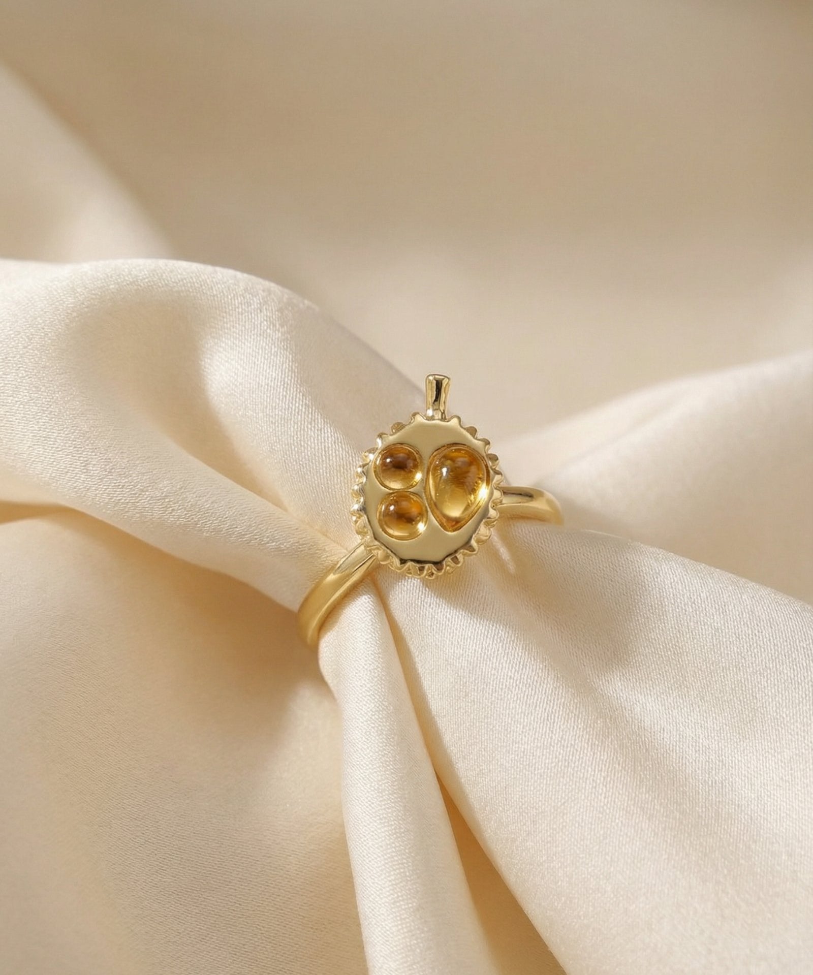 Durian Citrine Ring in yellow gold, laid flat on a tabletop