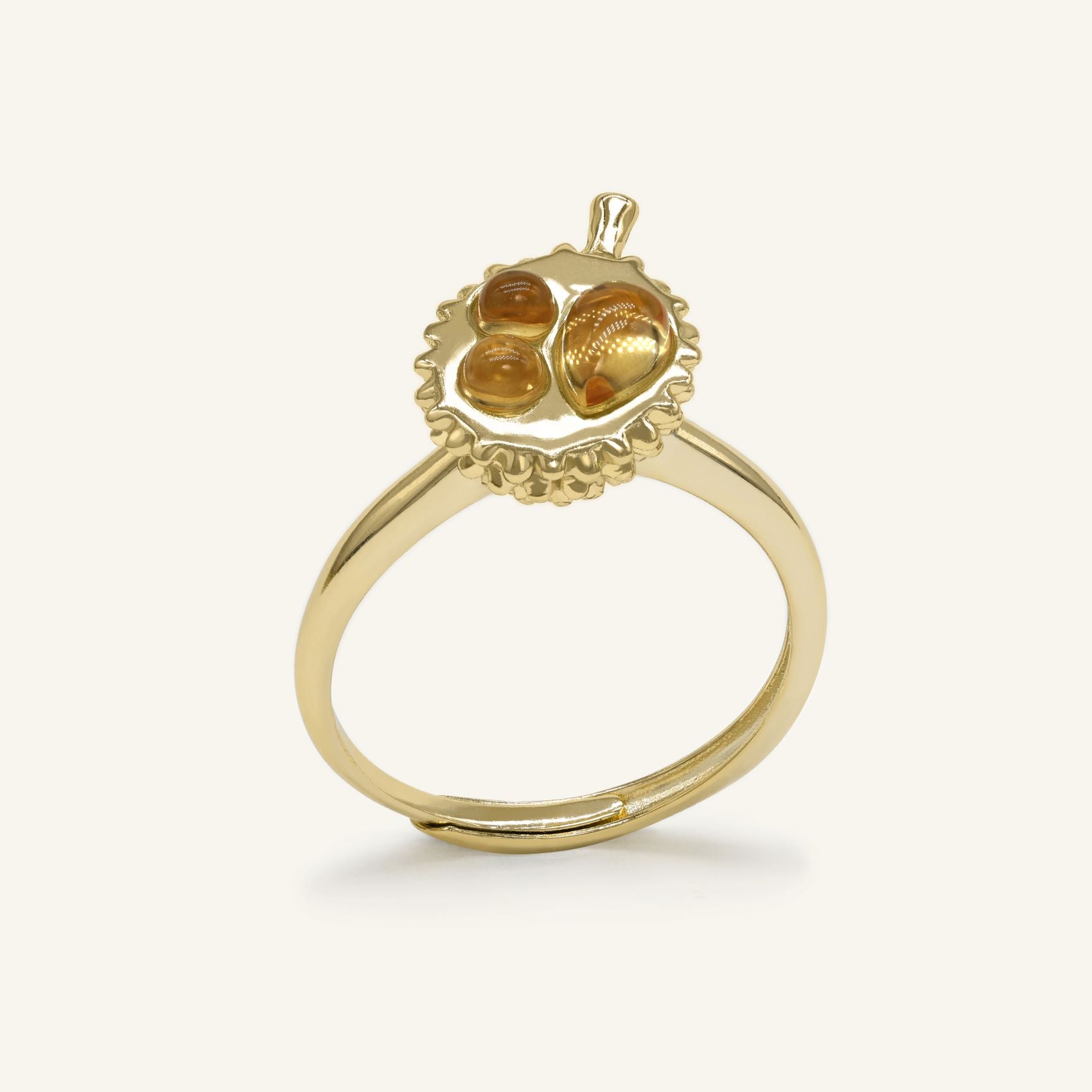 Close-up of the Durian Citrine Ring in yellow gold, resting on a warm linen background