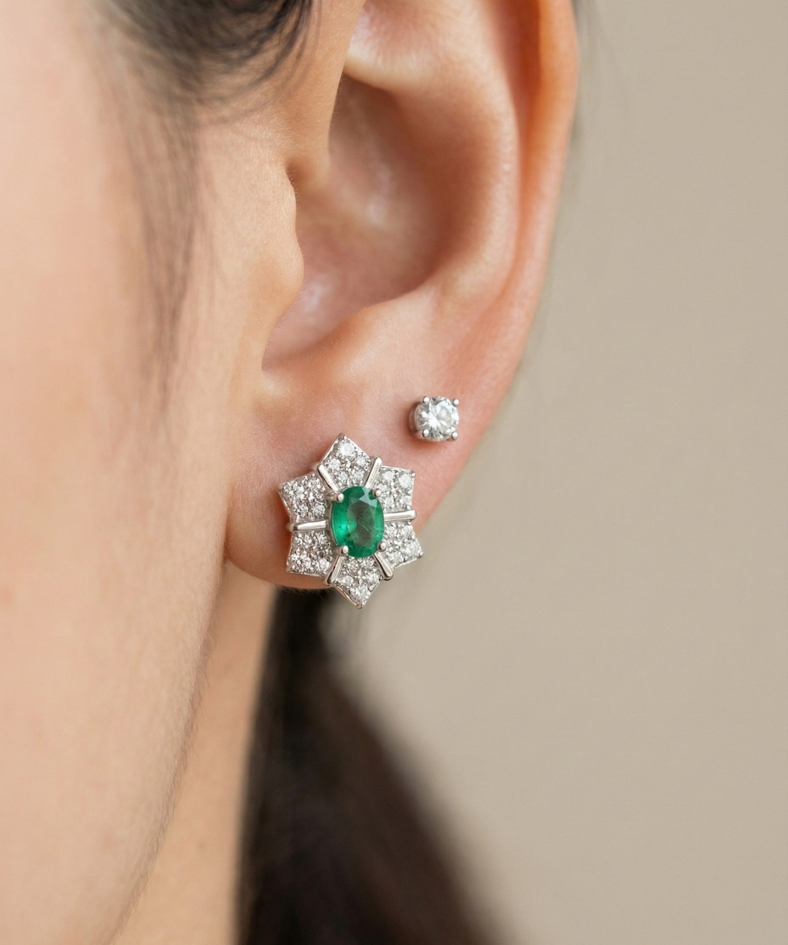 Direct on-ear view of the silver Emerald Starflower Studs, showcasing the clear, deep green of the natural Zambian emerald.