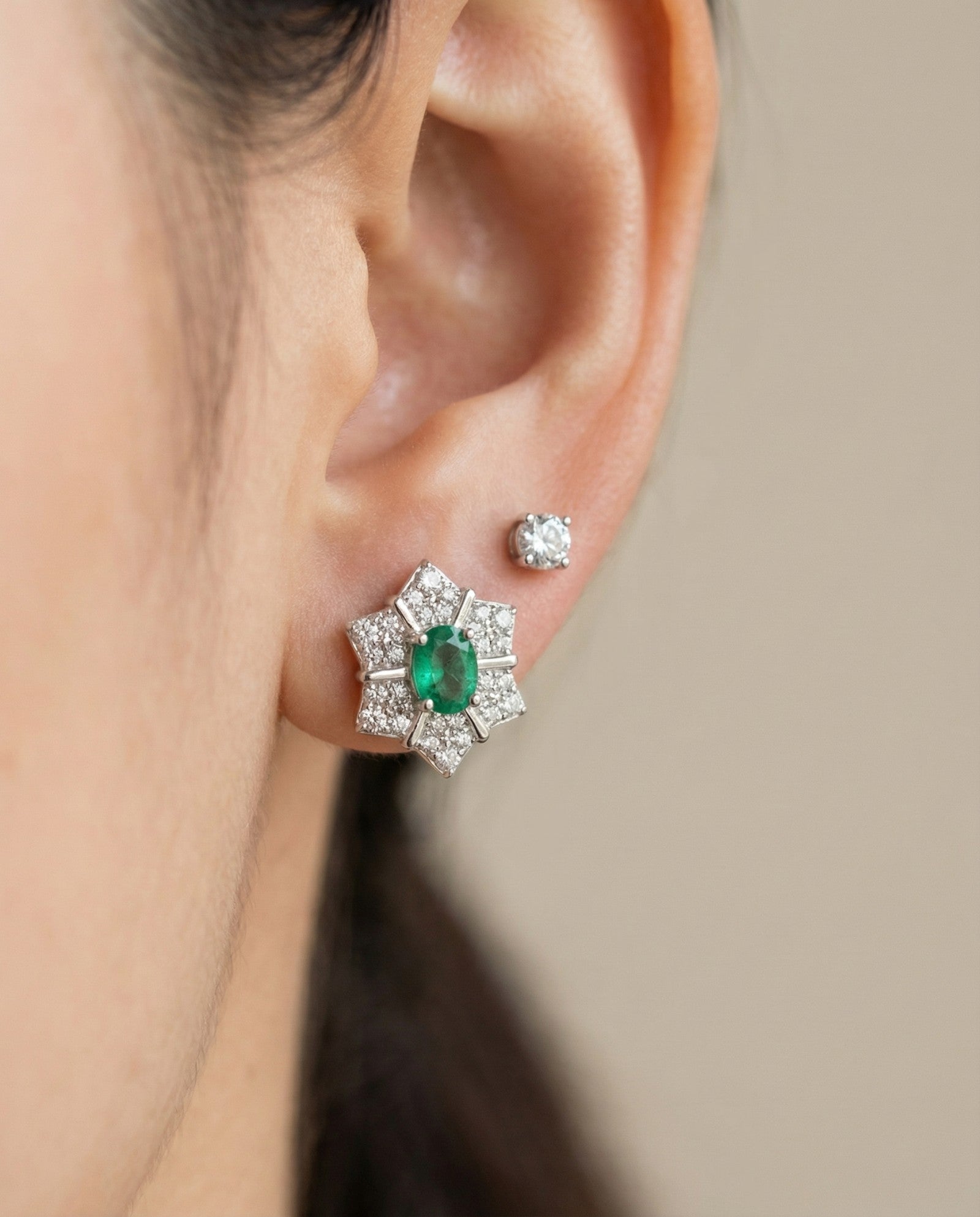 Direct on-ear view of the silver Emerald Starflower Studs, showcasing the clear, deep green of the natural Zambian emerald.