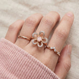 Eternal Rose Shell Ring in rose gold, worn on a model, stacked with other rings