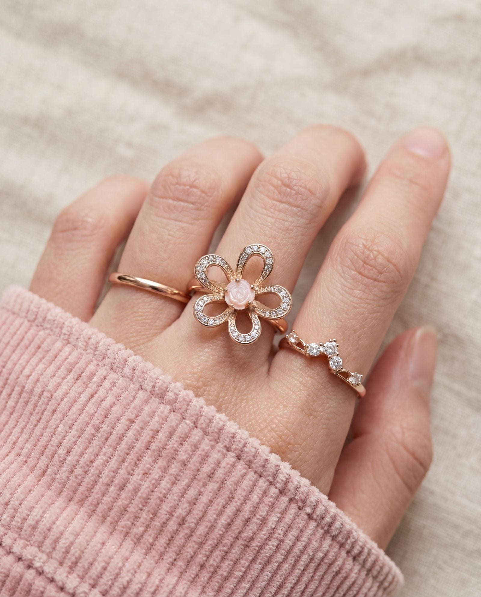 Eternal Rose Shell Ring in rose gold, worn on a model, stacked with other rings