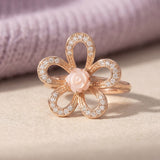 Eternal Rose Shell Ring in rose gold, laid flat on a tabletop, alternate angle