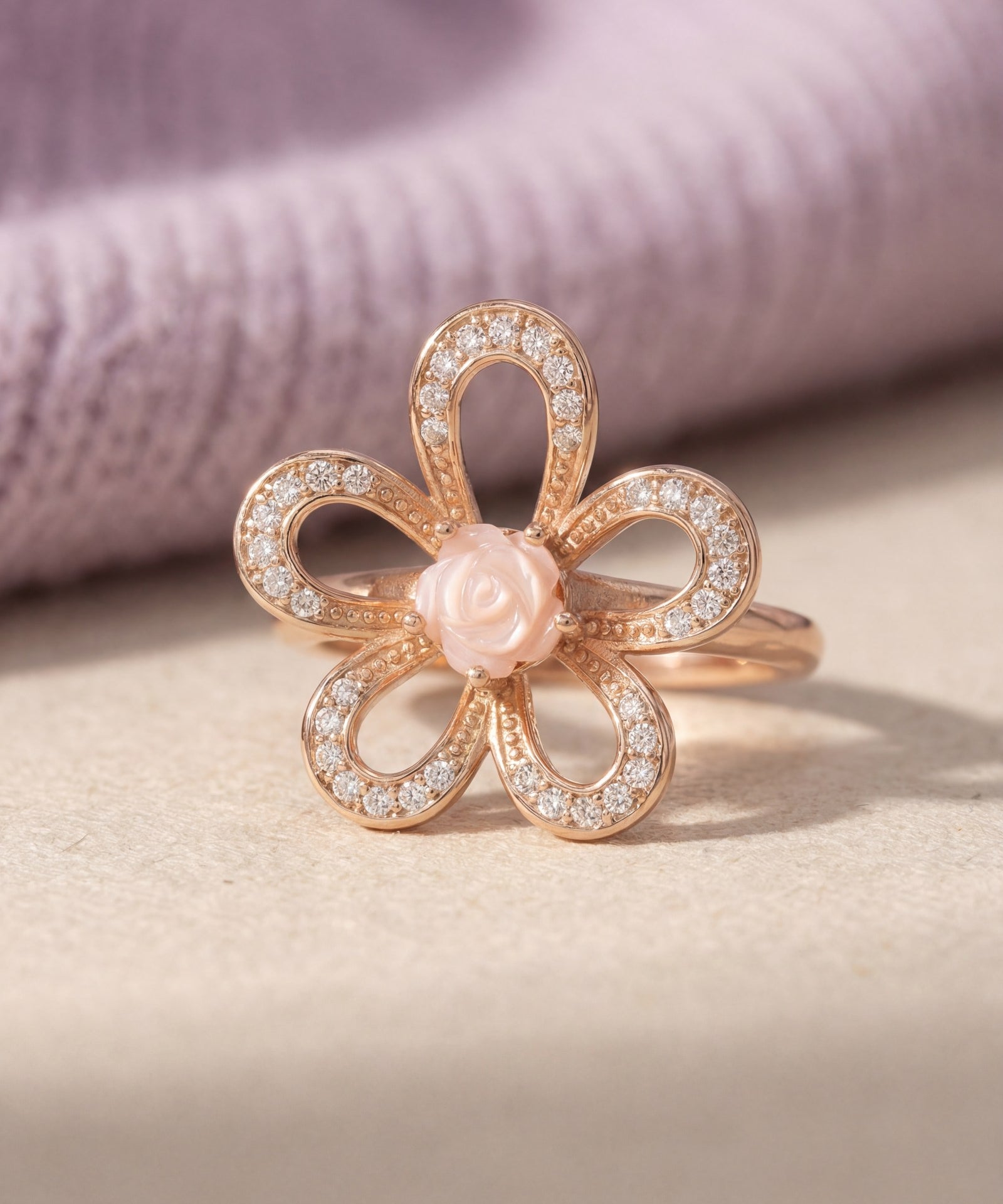 Eternal Rose Shell Ring in rose gold, laid flat on a tabletop, alternate angle