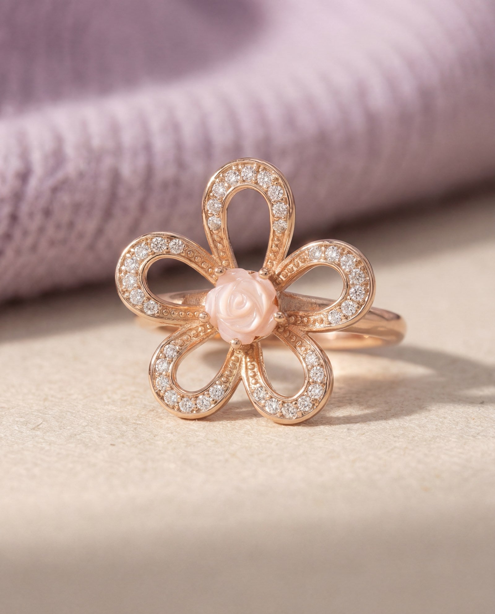 Eternal Rose Shell Ring in rose gold, laid flat on a tabletop, alternate angle