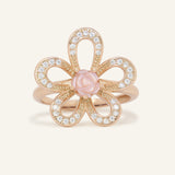 Eternal Rose Shell Ring in rose gold, resting on a warm linen background