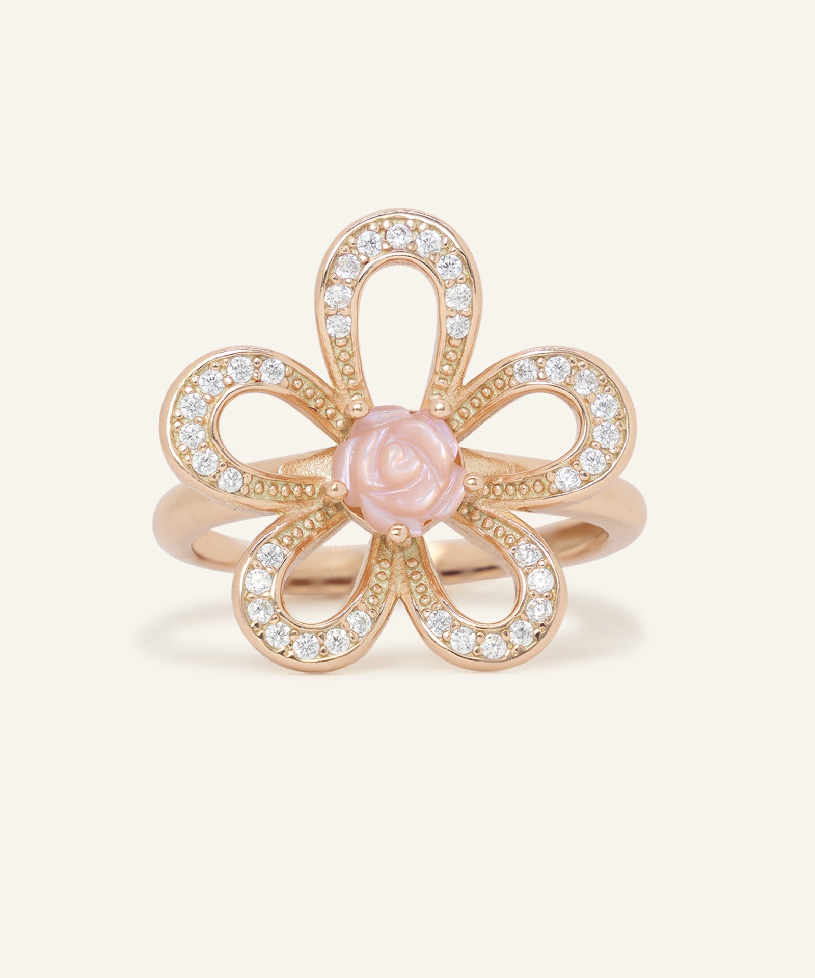 Eternal Rose Shell Ring in rose gold, resting on a warm linen background