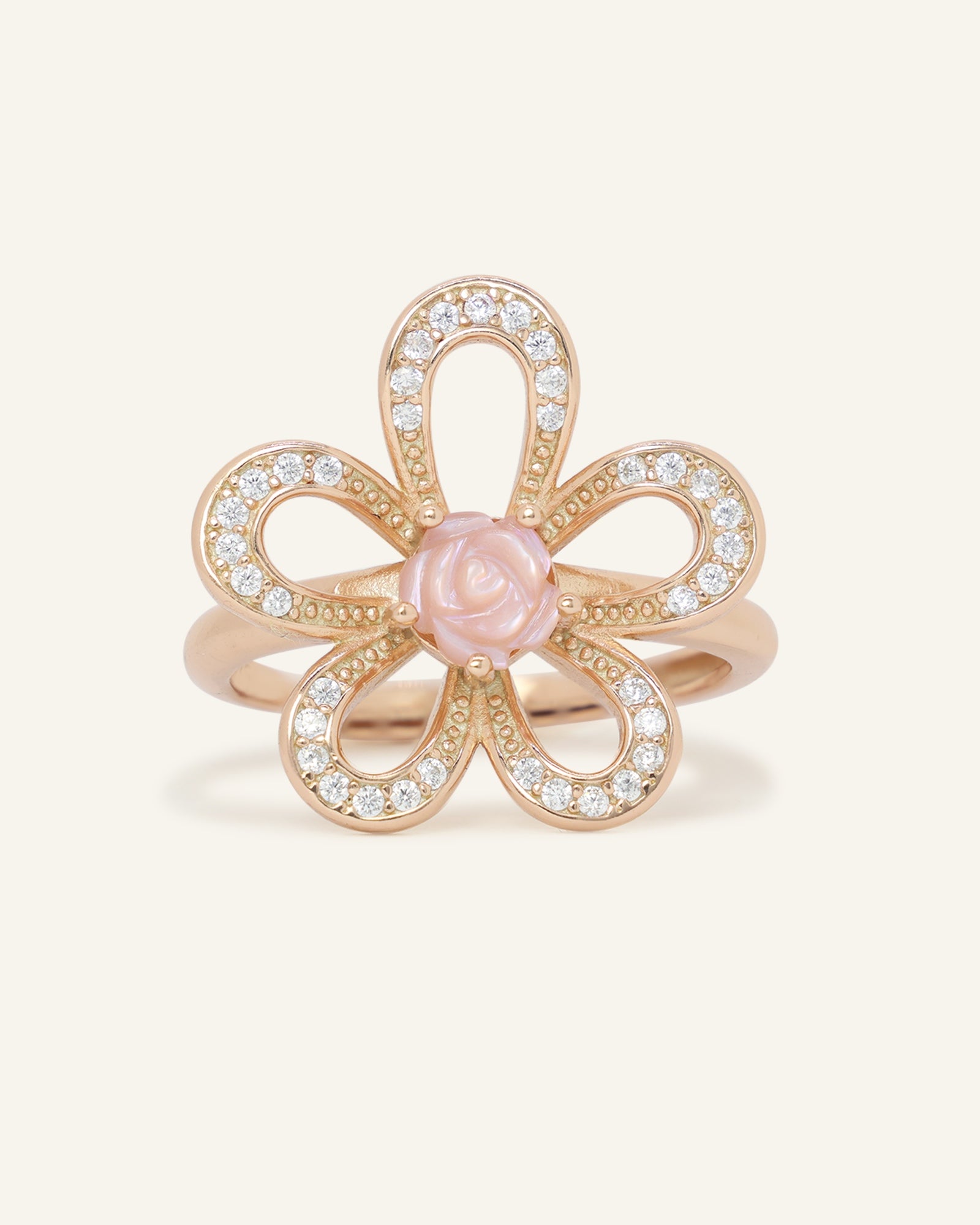 Eternal Rose Shell Ring in rose gold, resting on a warm linen background