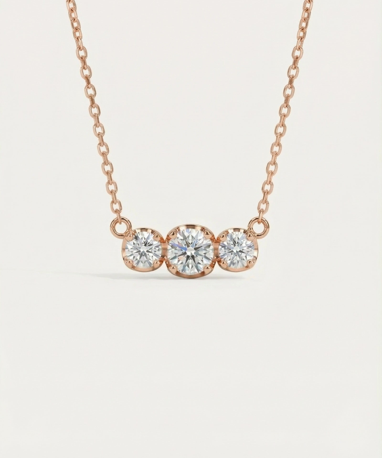 Main front-facing product image of the Everglow Trilogy Moissanite Necklace in 18k rose gold plating over 925 sterling silver.