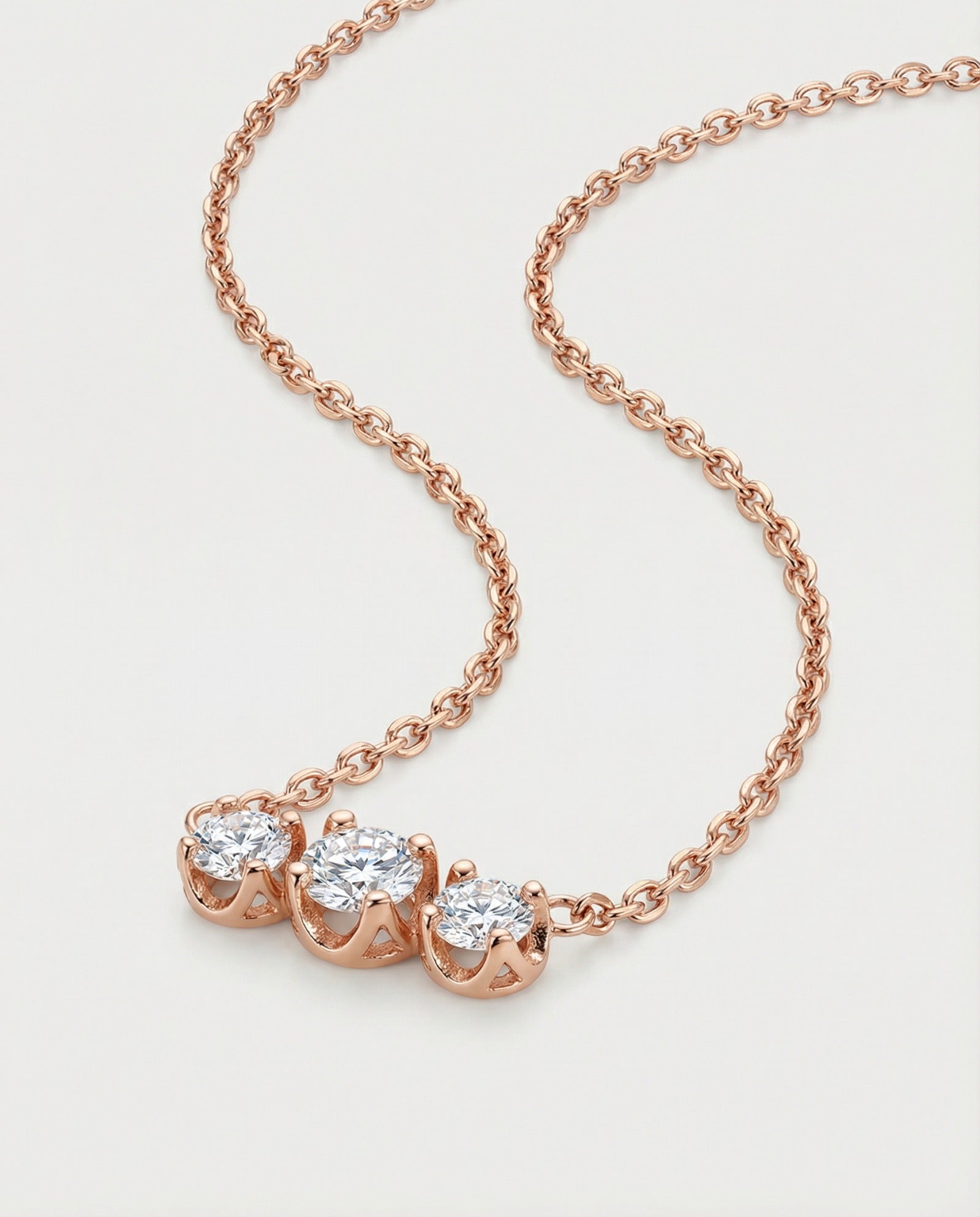 A professional product shot of the rose gold Everglow Trilogy Necklace, showcasing the fluid drape of the adjustable cable chain.