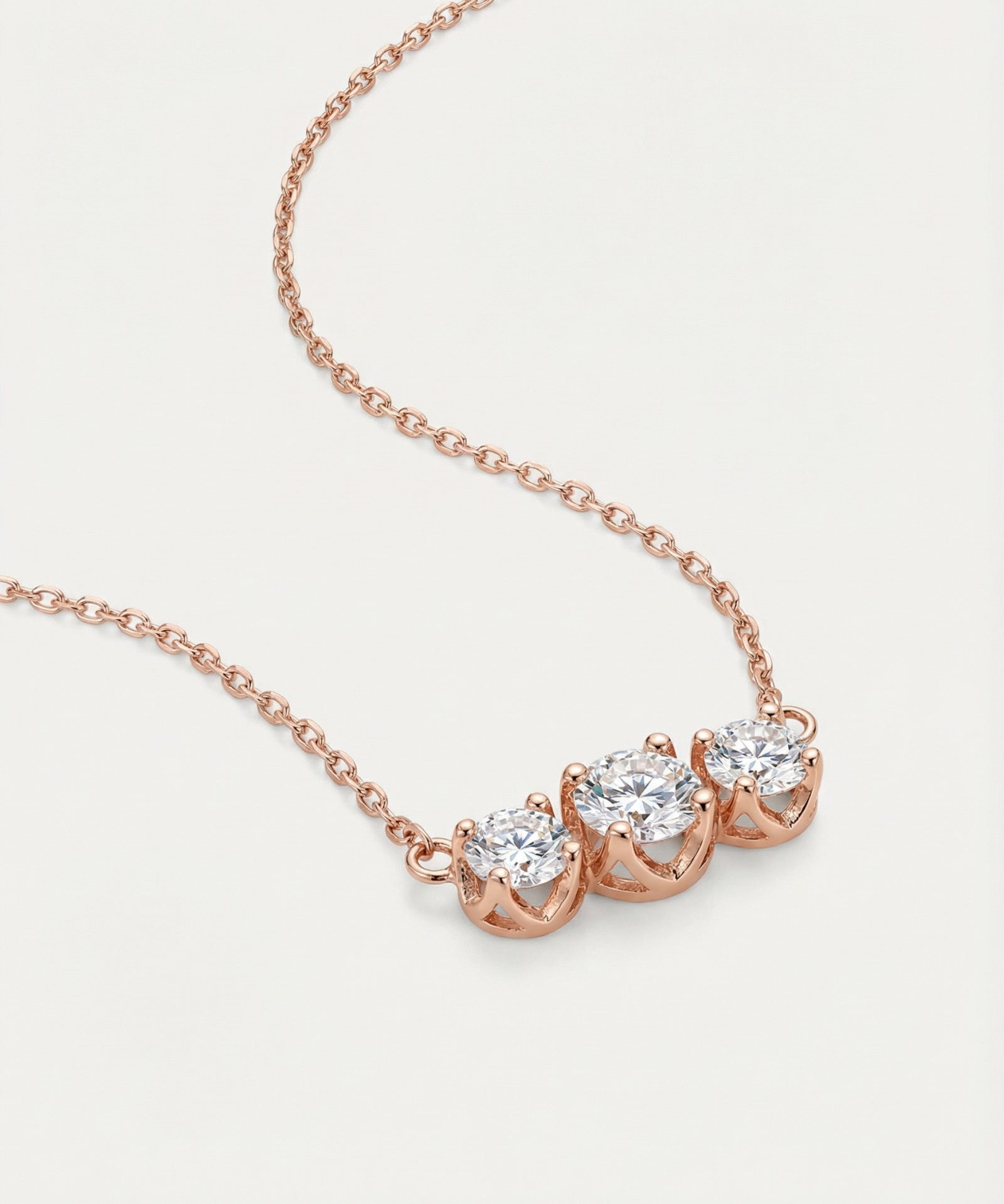 High-detail side view of the Everglow Trilogy Necklace in rose gold, showing the secure prong settings and fine-link cable chain.