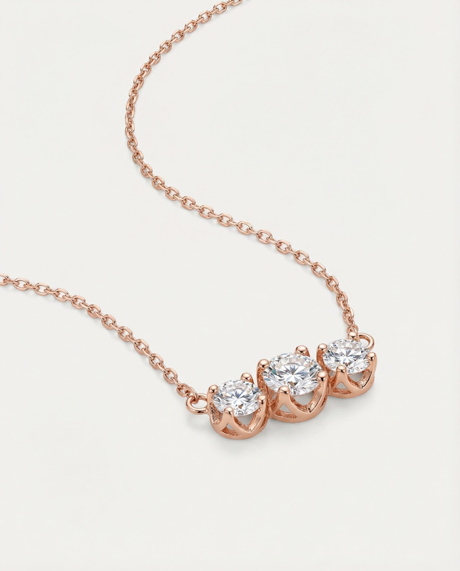High-detail side view of the Everglow Trilogy Necklace in rose gold, showing the secure prong settings and fine-link cable chain.