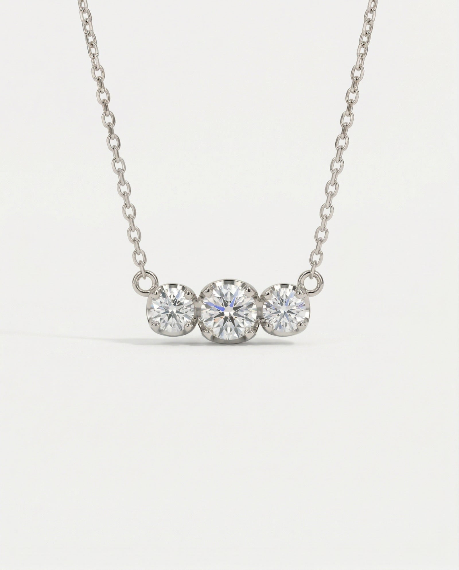 Product image of the Everglow Trilogy Moissanite Necklace in silver, highlighting the D-color VVS1 clarity of the stones.