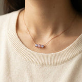 Model wearing the Rose Gold Everglow Trilogy Necklace, showing how the pink and lilac stones look against the skin.