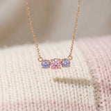 Everglow Trilogy Necklace in rose gold, displayed inside a high-end textured jewelry case.