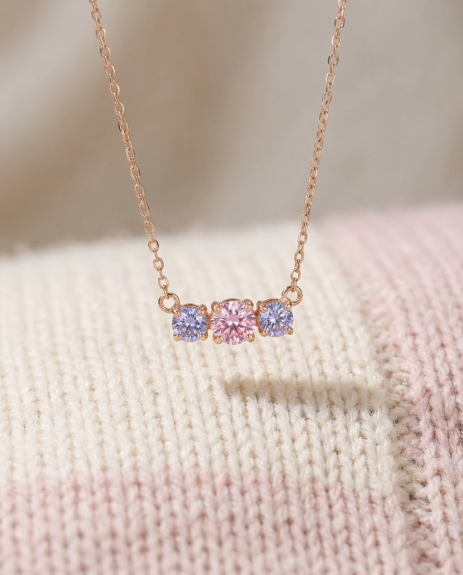 Everglow Trilogy Necklace in rose gold, displayed inside a high-end textured jewelry case.