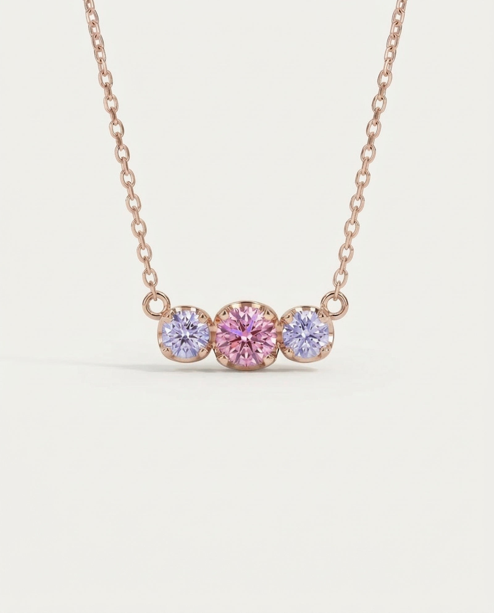 Front-facing product shot of the rose gold Everglow Trilogy Moissanite Necklace, highlighting the Cotton Candy pink and lilac stones.
