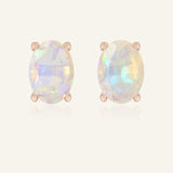 Close-up of the Prism Opal Studs in rose gold, resting on a warm linen background