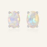 Prism Opal Studs in silver, resting on a warm linen background