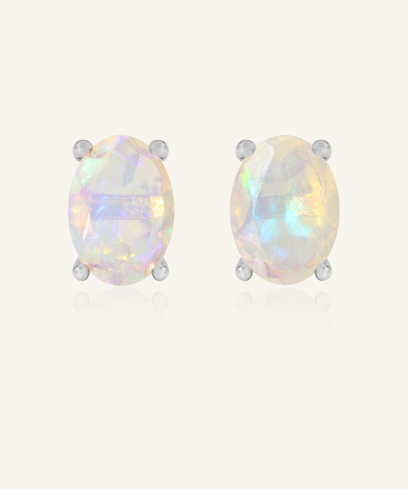 Prism Opal Studs in silver, resting on a warm linen background