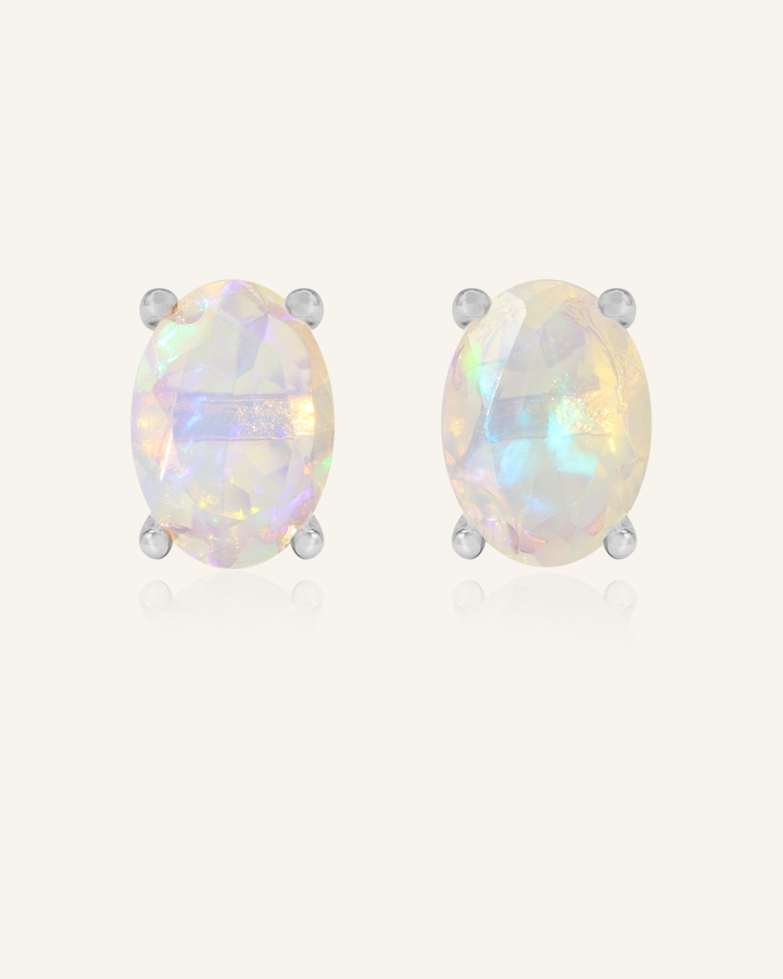 Prism Opal Studs in silver, resting on a warm linen background